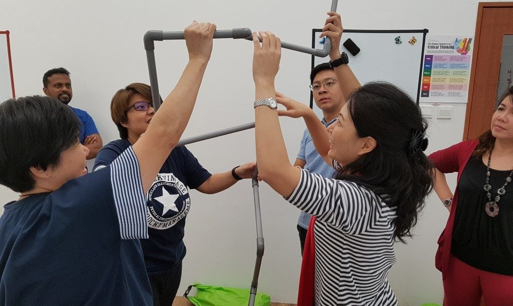 groups of people assembling pipes during workshop activity in Certified Advanced Behavioural Consultant Workshop